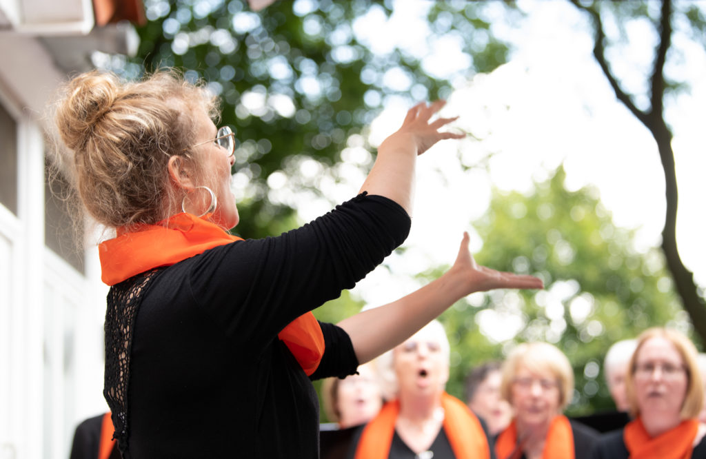 Anke Cordes conducting a choir outdoors